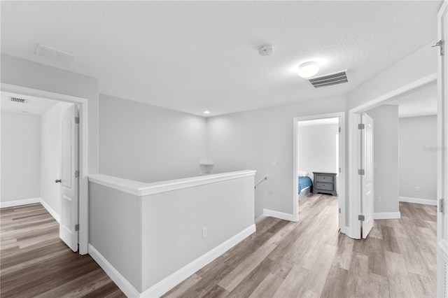 1902 Hailsham Ct, Orlando, FL 32824 - corridor featuring an upstairs landing, wood finished floors, baseboards, and a textured ceiling