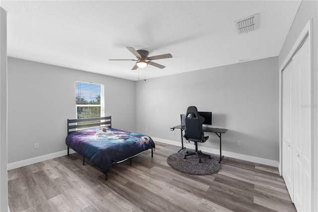 1902 Hailsham Ct, Orlando, FL 32824 - bedroom with wood finished floors, baseboards, an office area, and a ceiling fan