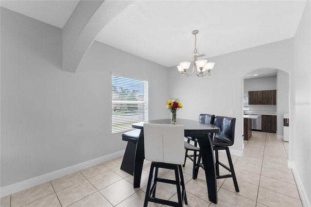 1902 Hailsham Ct, Orlando, FL 32824 - dining space featuring arched walkways, a chandelier, light tile patterned flooring, and baseboards