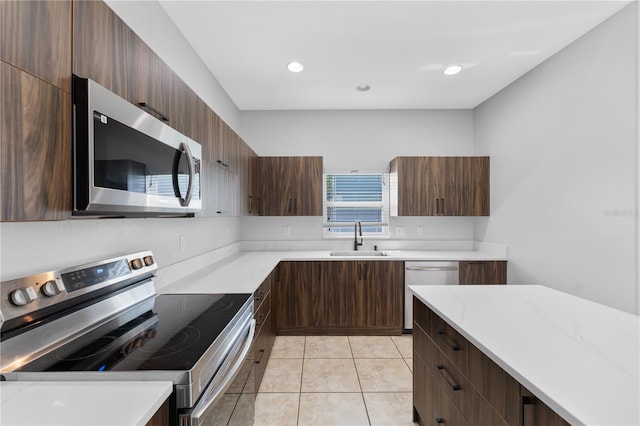1902 Hailsham Ct, Orlando, FL 32824 - kitchen featuring stainless steel appliances, a sink, modern cabinets, light stone countertops, and light tile patterned floors