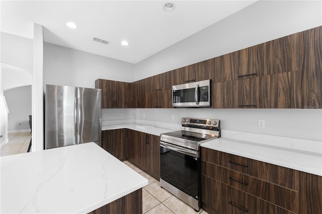 1902 Hailsham Ct, Orlando, FL 32824 - kitchen featuring stainless steel appliances, modern cabinets, light tile patterned floors, light stone countertops, and recessed lighting