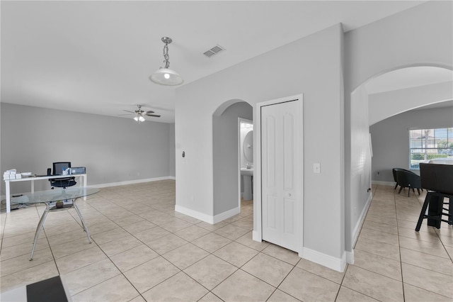 1902 Hailsham Ct, Orlando, FL 32824 - spare room featuring arched walkways, light tile patterned floors, a ceiling fan, and baseboards