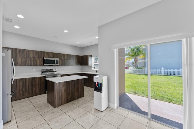 1902 Hailsham Ct, Orlando, FL 32824 - kitchen with stainless steel appliances, a sink, a kitchen island, light countertops, and dark brown cabinets