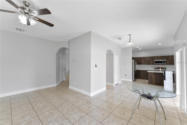 1902 Hailsham Ct, Orlando, FL 32824 - unfurnished living room featuring arched walkways, ceiling fan, light tile patterned floors, recessed lighting, and baseboards
