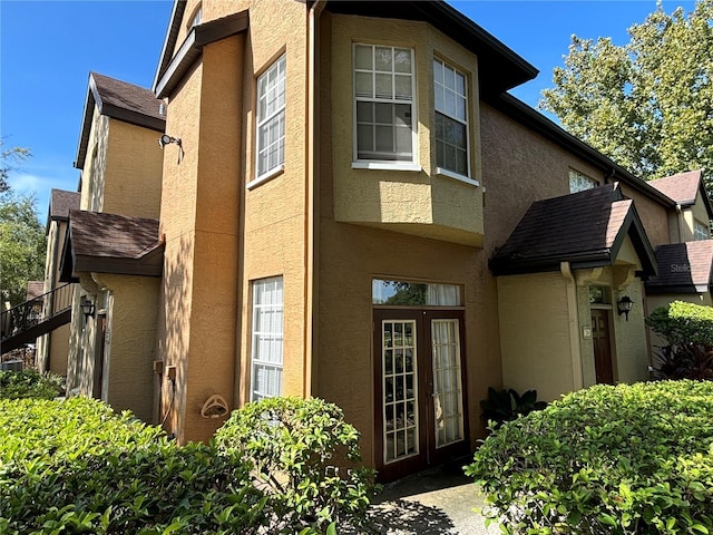 view of side of property with stucco siding and french doors