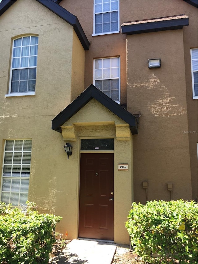 view of exterior entry featuring stucco siding