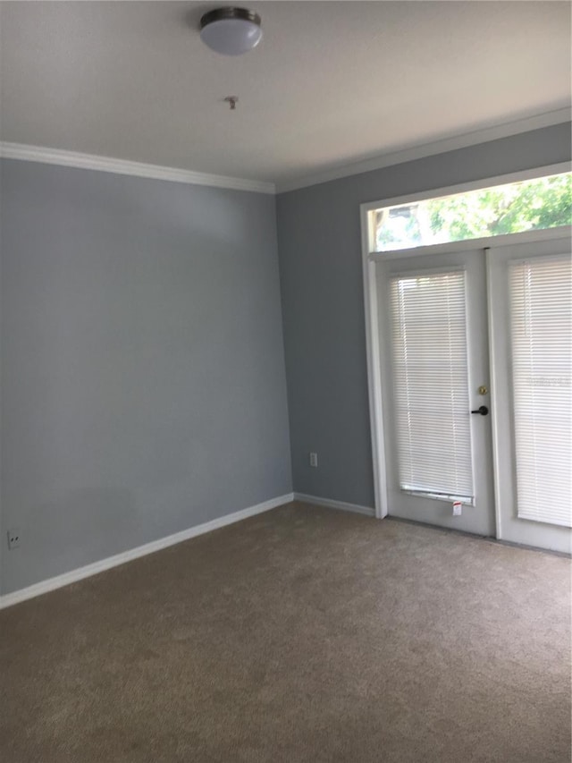 carpeted empty room with ornamental molding and baseboards