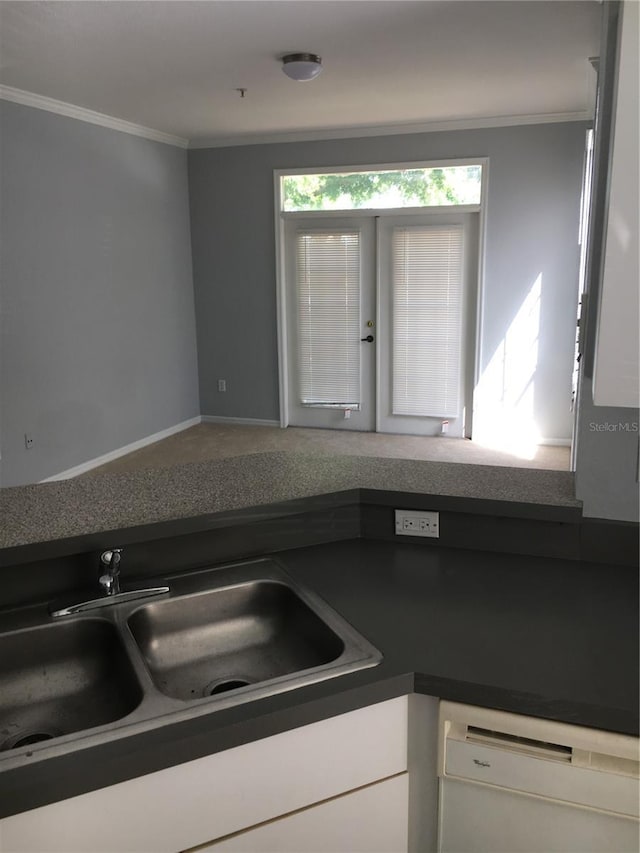 kitchen with dishwasher, a sink, ornamental molding, dark countertops, and french doors