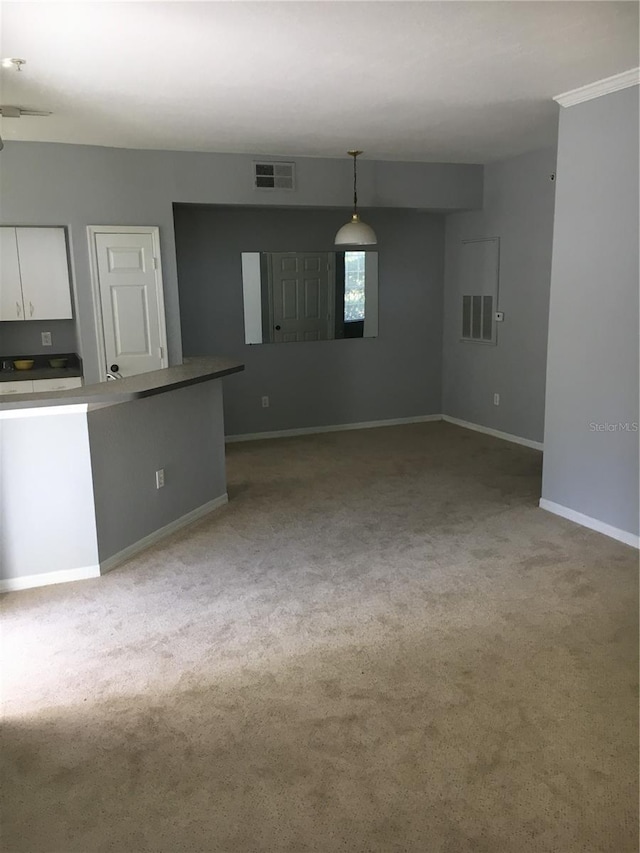 unfurnished living room featuring carpet flooring and baseboards