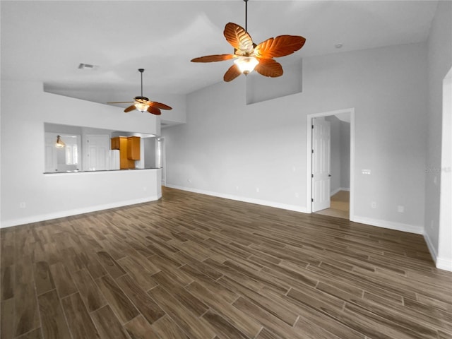 84 Camino Real Blvd, Howey In The Hills, FL 34737 - unfurnished living room featuring a ceiling fan, lofted ceiling, dark wood-type flooring, and baseboards