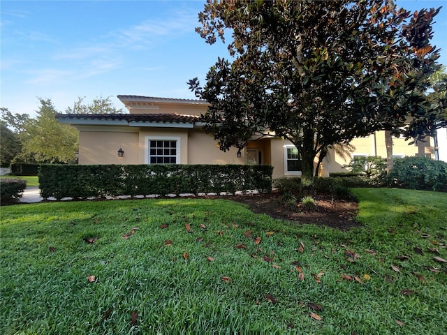 84 Camino Real Blvd, Howey In The Hills, FL 34737 - view of front facade featuring stucco siding, a front lawn, and a tiled roof