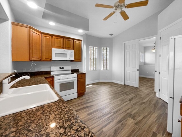 84 Camino Real Blvd, Howey In The Hills, FL 34737 - kitchen featuring white appliances, a sink, a ceiling fan, dark countertops, and lofted ceiling