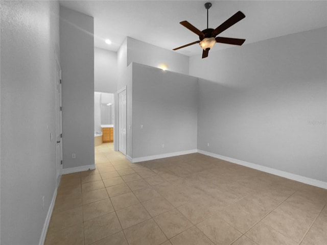 84 Camino Real Blvd, Howey In The Hills, FL 34737 - spare room with ceiling fan, light tile patterned flooring, baseboards, and a towering ceiling