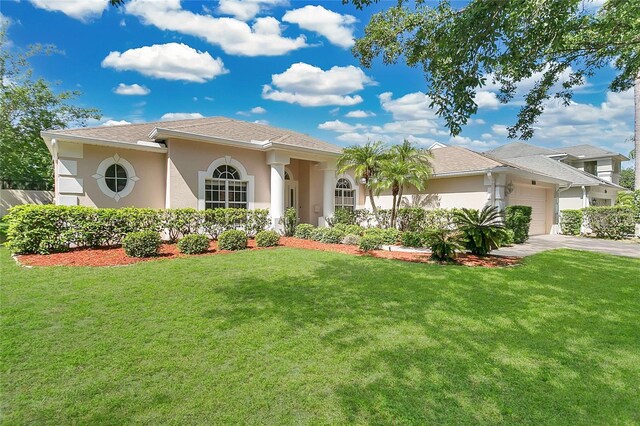 7900 Saint Giles Pl, Orlando, FL 32835 - mediterranean / spanish home with a garage, stucco siding, a front lawn, and driveway