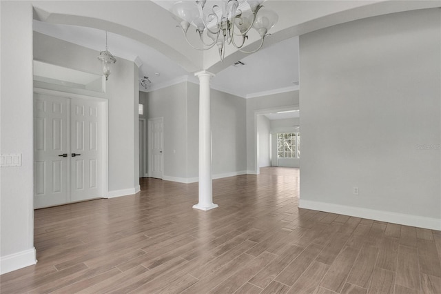 7900 Saint Giles Pl, Orlando, FL 32835 - empty room featuring ornamental molding, decorative columns, a chandelier, baseboards, and light wood finished floors