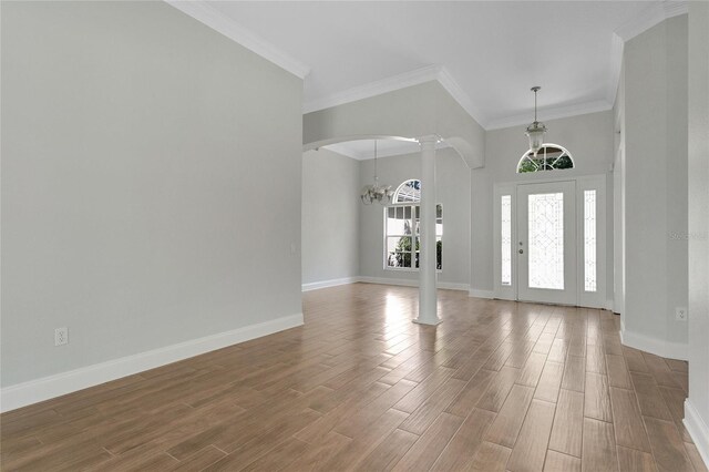 7900 Saint Giles Pl, Orlando, FL 32835 - foyer entrance featuring decorative columns, arched walkways, baseboards, wood finished floors, and crown molding