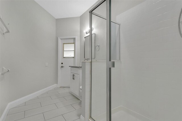 7900 Saint Giles Pl, Orlando, FL 32835 - bathroom with a shower stall, vanity, baseboards, and tile patterned flooring