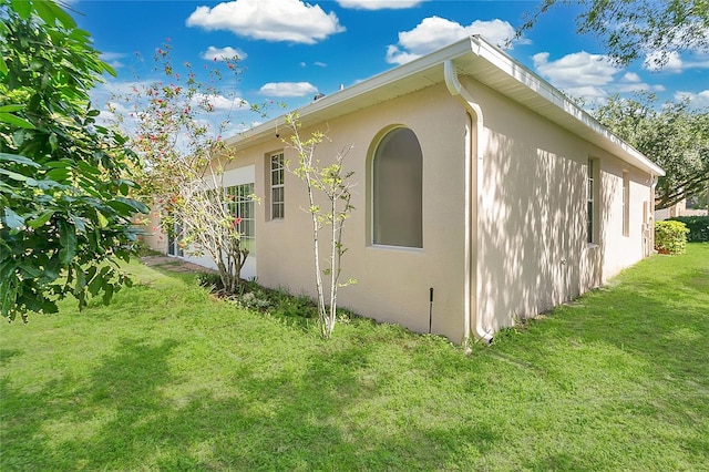 7900 Saint Giles Pl, Orlando, FL 32835 - view of side of home with stucco siding and a yard