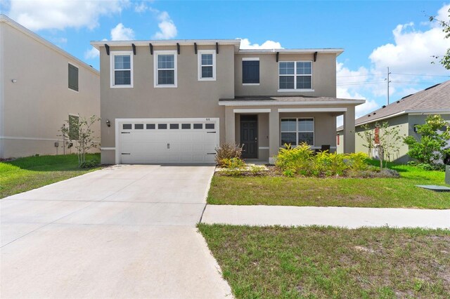 616 Griffon Ave, Lake Alfred, FL 33850 - view of front facade with stucco siding, concrete driveway, a garage, and a front lawn