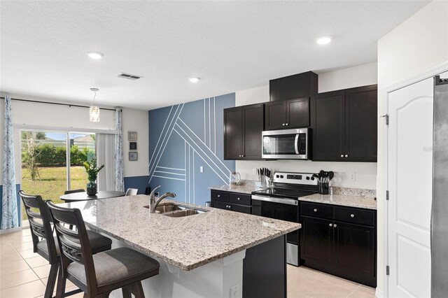 616 Griffon Ave, Lake Alfred, FL 33850 - kitchen featuring appliances with stainless steel finishes, a sink, a kitchen breakfast bar, light stone countertops, and recessed lighting