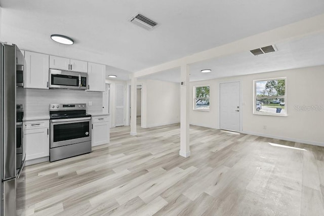 4119 Beacon Square Dr, Holiday, FL 34691 - kitchen featuring appliances with stainless steel finishes, white cabinets, light countertops, and tasteful backsplash