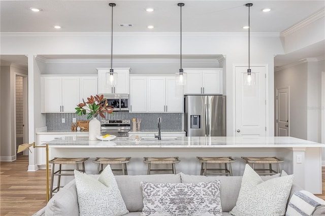 5 Heuchera Ct E, Homosassa, FL 34446 - kitchen featuring stainless steel appliances, a sink, white cabinetry, backsplash, and a breakfast bar