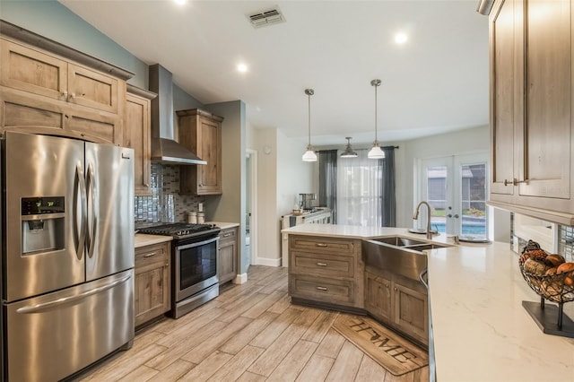 2113 Kirkland Lake Dr, Auburndale, FL 33823 - kitchen featuring stainless steel appliances, a sink, wall chimney exhaust hood, backsplash, and light wood-style floors