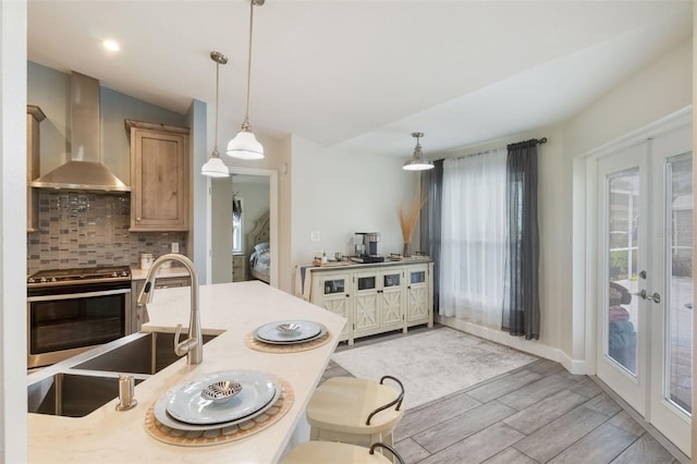 2113 Kirkland Lake Dr, Auburndale, FL 33823 - kitchen with wall chimney exhaust hood, stainless steel range oven, tasteful backsplash, light wood finished floors, and light countertops