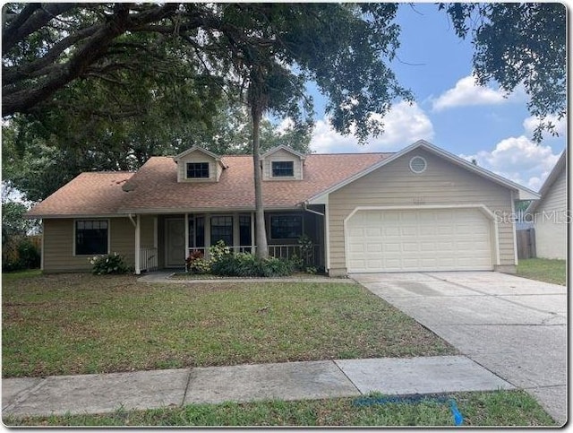 1606 Red Clover Ct, Orlando, FL 32825 - view of front of home featuring an attached garage, a front yard, driveway, and a porch