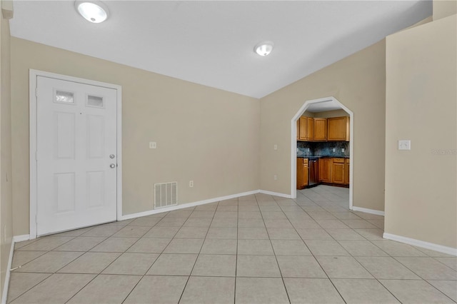 1614 Christa Ct, Saint Cloud, FL 34772 - unfurnished living room featuring arched walkways, baseboards, and light tile patterned flooring