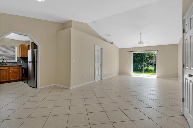 1614 Christa Ct, Saint Cloud, FL 34772 - unfurnished room featuring a ceiling fan, vaulted ceiling, light tile patterned floors, baseboards, and a sink