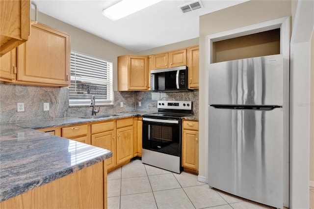 1614 Christa Ct, Saint Cloud, FL 34772 - kitchen featuring appliances with stainless steel finishes, light brown cabinetry, a sink, light tile patterned flooring, and decorative backsplash