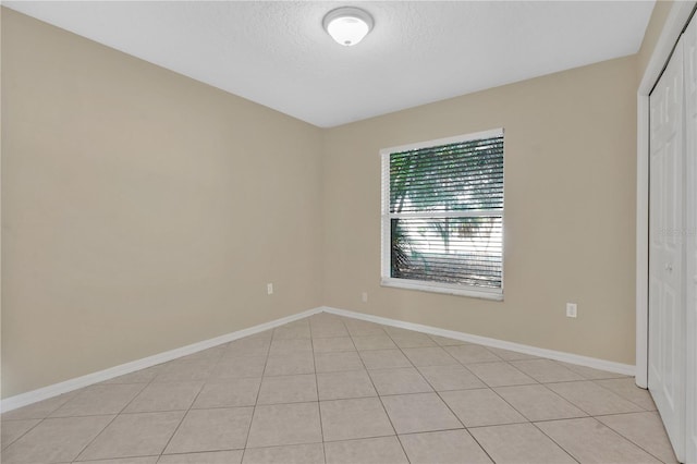 1614 Christa Ct, Saint Cloud, FL 34772 - empty room featuring a textured ceiling, light tile patterned flooring, and baseboards
