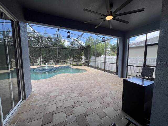 14936 Masthead Landing Cir, Winter Garden, FL 34787 - view of swimming pool featuring ceiling fan, a patio area, a pool with connected hot tub, and glass enclosure
