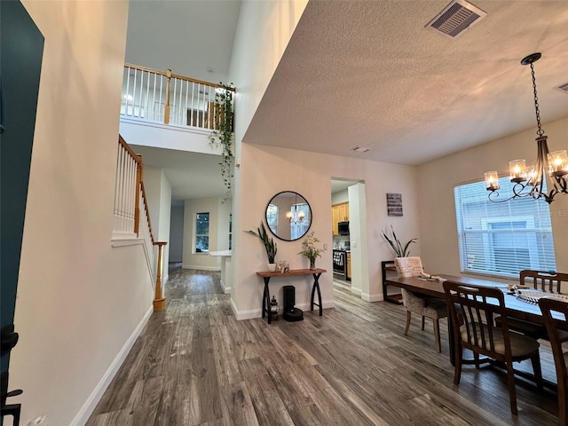 14936 Masthead Landing Cir, Winter Garden, FL 34787 - dining room with dark wood-style floors, a chandelier, stairway, baseboards, and a textured ceiling