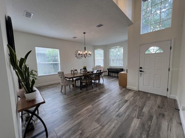 14936 Masthead Landing Cir, Winter Garden, FL 34787 - dining area with a chandelier, plenty of natural light, dark wood finished floors, baseboards, and a textured ceiling