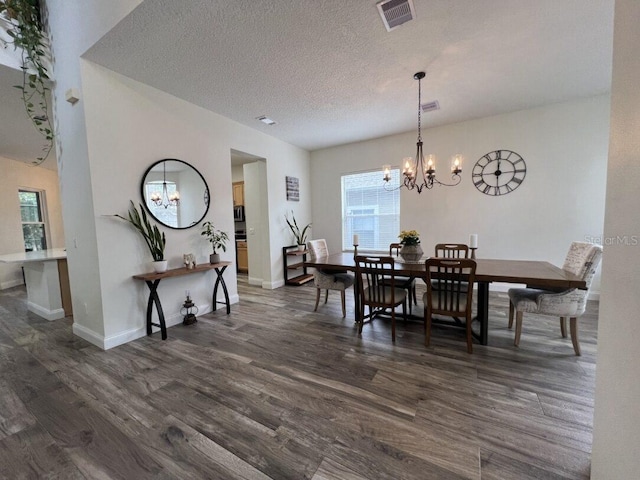 14936 Masthead Landing Cir, Winter Garden, FL 34787 - dining area featuring a chandelier, dark wood finished floors, a textured ceiling, and baseboards