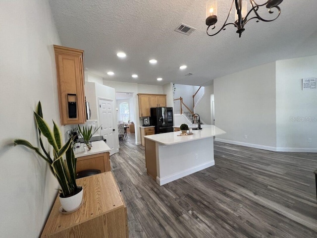 14936 Masthead Landing Cir, Winter Garden, FL 34787 - kitchen featuring freestanding refrigerator, a textured ceiling, dark wood-style flooring, light countertops, and an island with sink