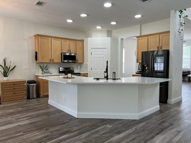 14936 Masthead Landing Cir, Winter Garden, FL 34787 - kitchen featuring stainless steel appliances, a sink, dark wood-style flooring, light countertops, and a kitchen island with sink