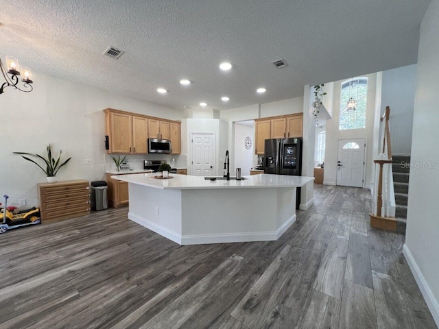 14936 Masthead Landing Cir, Winter Garden, FL 34787 - kitchen with appliances with stainless steel finishes, a sink, an island with sink, dark wood-style floors, and light countertops
