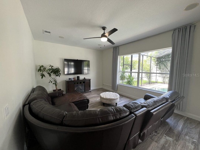 14936 Masthead Landing Cir, Winter Garden, FL 34787 - living area with wood finished floors, a textured ceiling, baseboards, and a ceiling fan