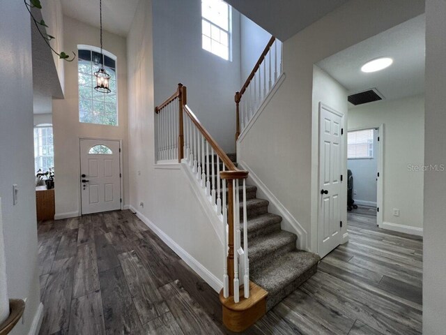 14936 Masthead Landing Cir, Winter Garden, FL 34787 - foyer entrance with wood finished floors, stairs, a high ceiling, a chandelier, and baseboards