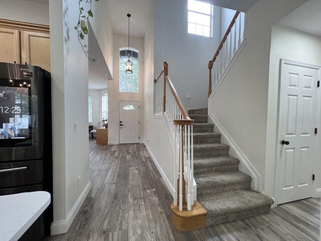 14936 Masthead Landing Cir, Winter Garden, FL 34787 - entryway featuring a high ceiling, plenty of natural light, stairs, and wood finished floors