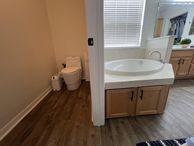 14936 Masthead Landing Cir, Winter Garden, FL 34787 - bathroom featuring a bath, toilet, wood finished floors, and baseboards