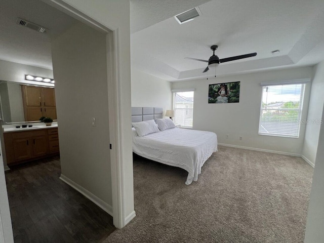 14936 Masthead Landing Cir, Winter Garden, FL 34787 - bedroom featuring a tray ceiling, baseboards, ensuite bathroom, and ceiling fan