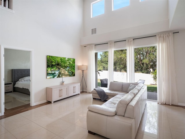 13156 Hatherton Cir, Orlando, FL 32832 - living area with light tile patterned flooring, a towering ceiling, and baseboards