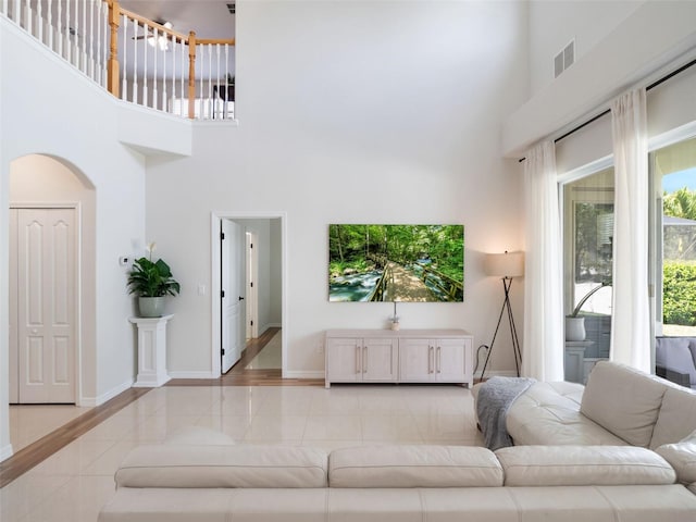 13156 Hatherton Cir, Orlando, FL 32832 - living area featuring a towering ceiling, light tile patterned floors, baseboards, and arched walkways