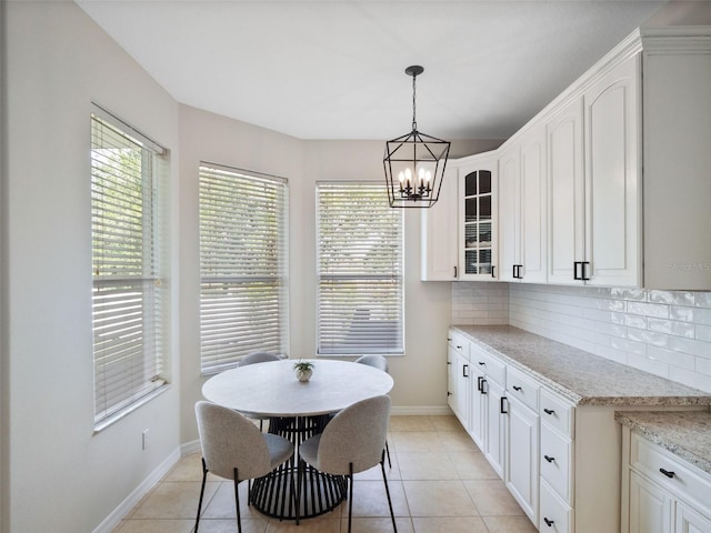 13156 Hatherton Cir, Orlando, FL 32832 - dining space with baseboards, a chandelier, and light tile patterned floors