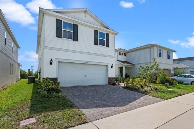 10245 Park Estates Ave, Orlando, FL 32836 - traditional-style house featuring decorative driveway, central AC, a garage, board and batten siding, and stucco siding
