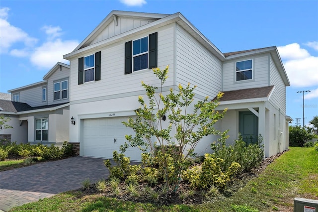 10245 Park Estates Ave, Orlando, FL 32836 - view of front of property featuring a garage, a shingled roof, board and batten siding, and decorative driveway